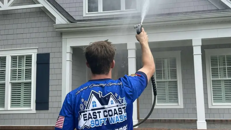 A close-up of a technician using pressure washing to clean a home's siding, removing grime and mold for a bright finish.